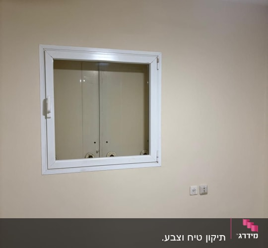 קיר צבוע עם חלון קטן ותקרה